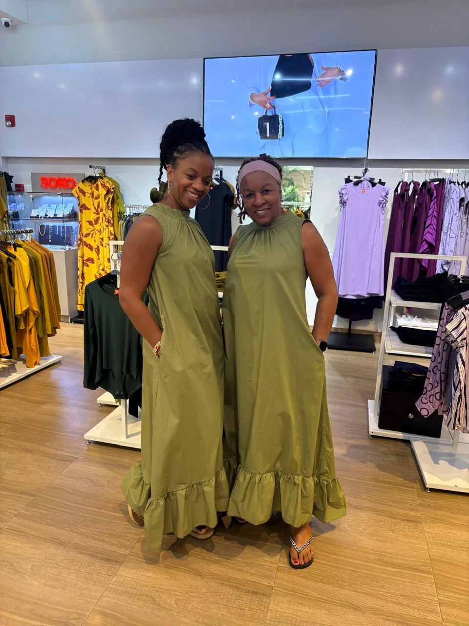 Two guests in olive dresses browsing a Nairobi boutique